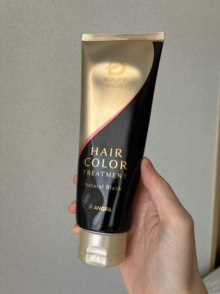 スカルプDボーテ ヘアカラートリートメント(ナチュラルブラック)の容器を手に持ったところ